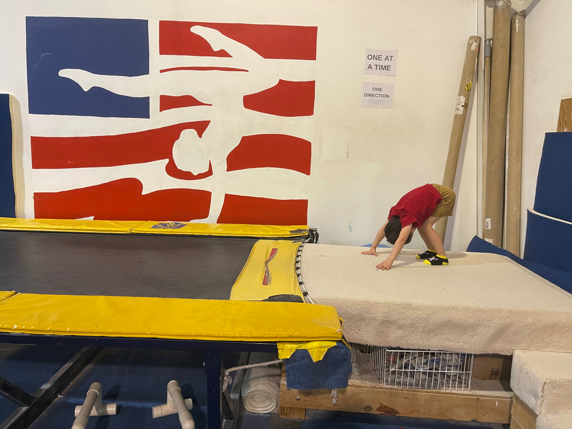 Noah doing a handstand in front of the painted flag mural