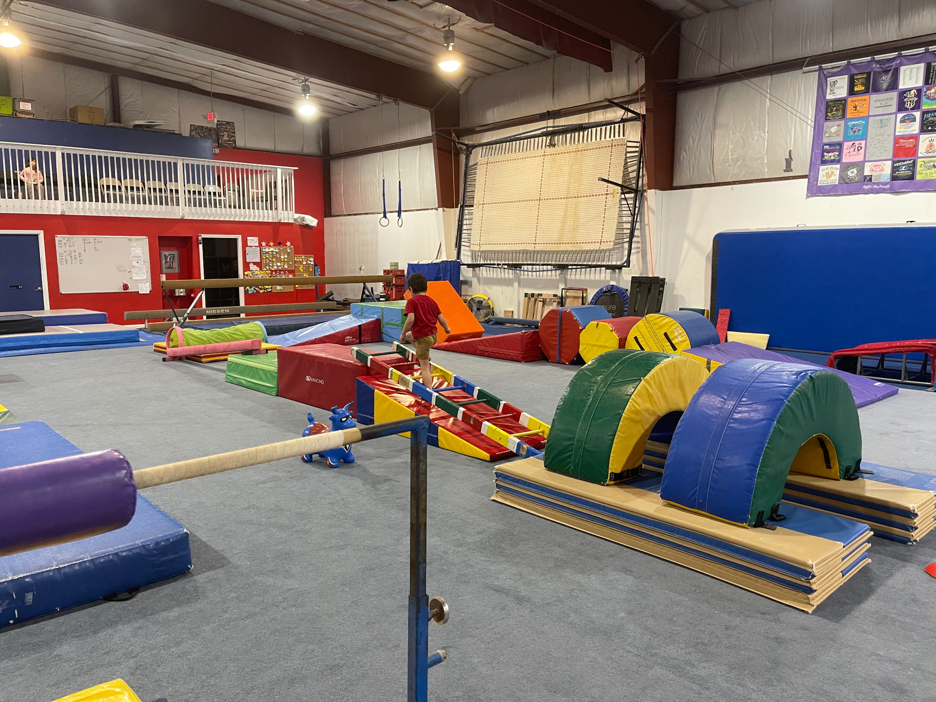 Noah running across the colorful obstacle course at the gym