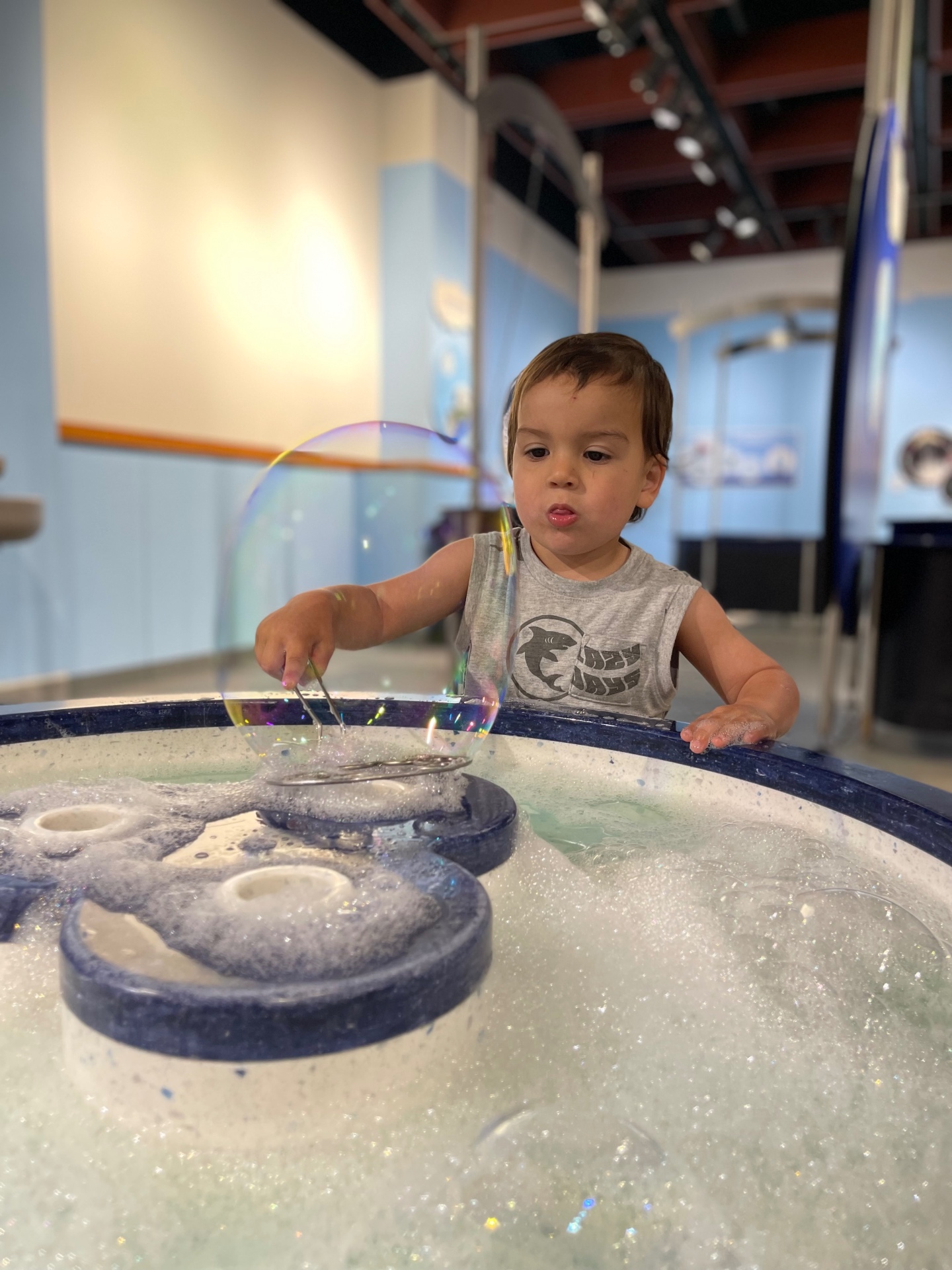 Toddler making giant bubbles at a science museum